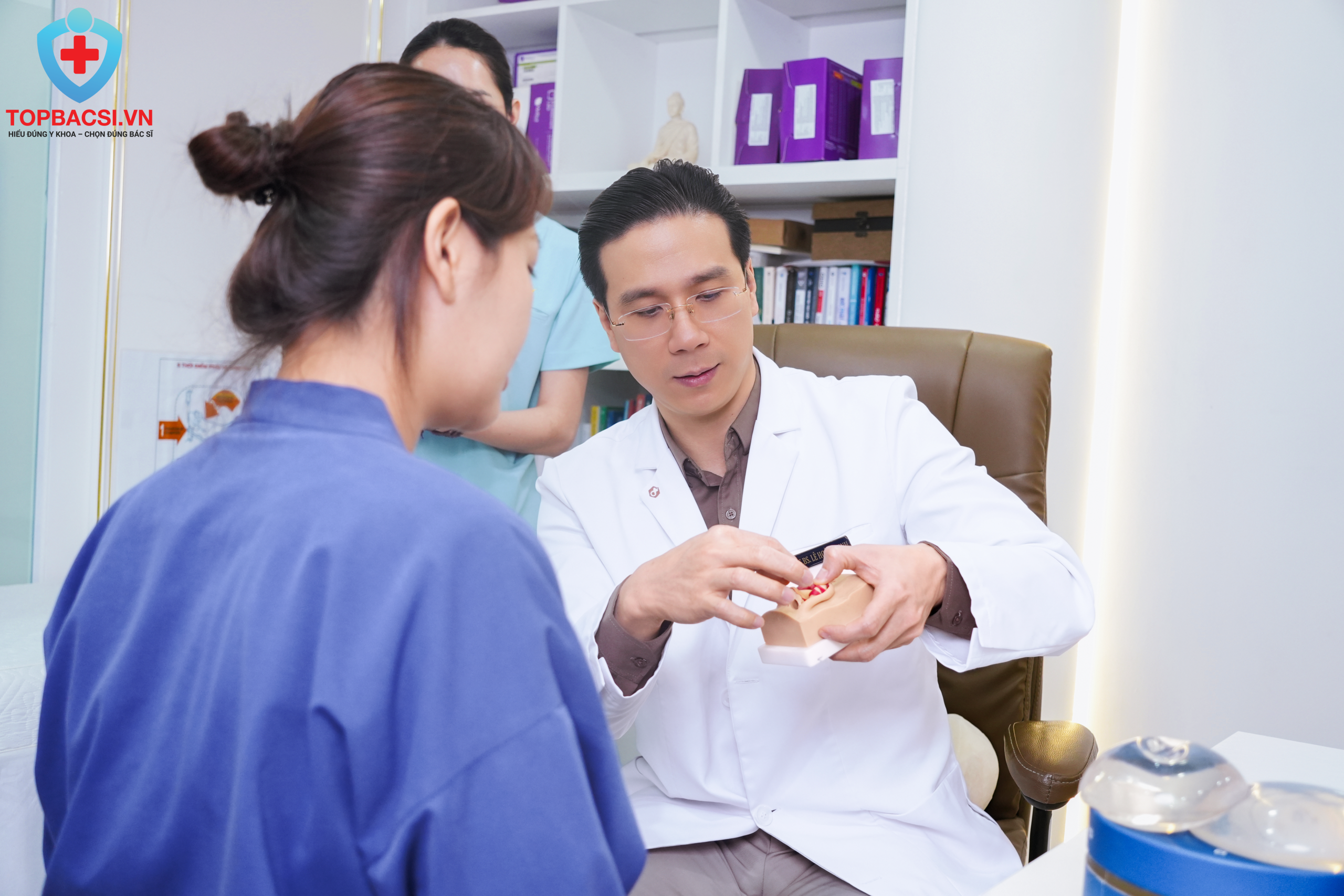 Thạc sĩ Bác sĩ Lê Hoàng Vinh tư vấn chi tiết bằng mô hình giải phẫu cho khách hàng.